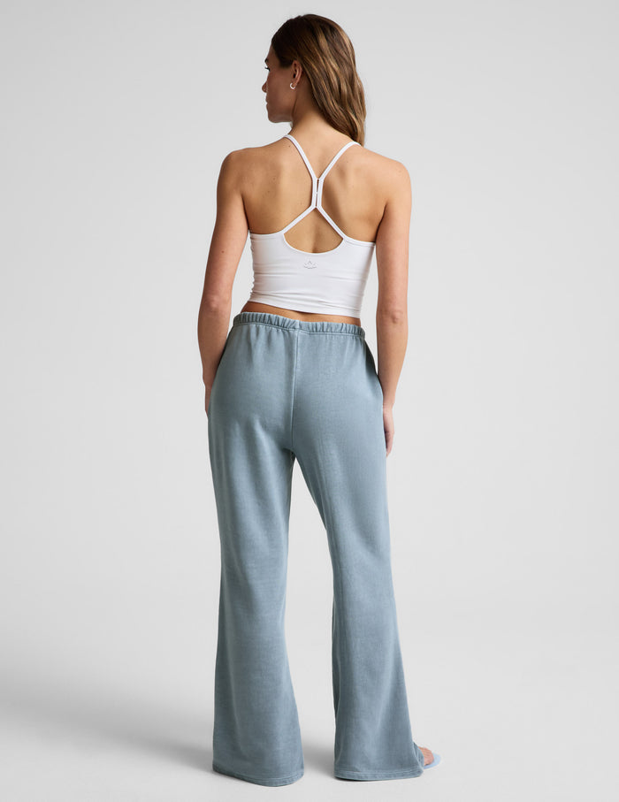 Rear view of light blue Fade Out Mid-Rise Sweatpant featuring a gathered elastic waistband and full-length flared legs.