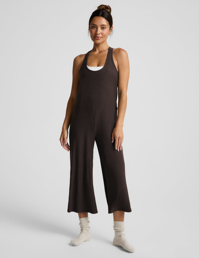 Woman wearing a brown cropped jumpsuit against a plain background.