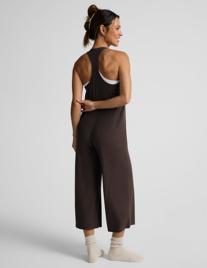 Woman wearing a brown cropped jumpsuit against a plain background.