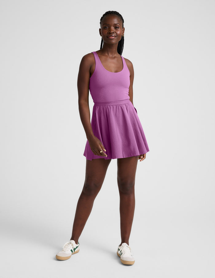 Woman wearing a purple mini dress against a plain background.