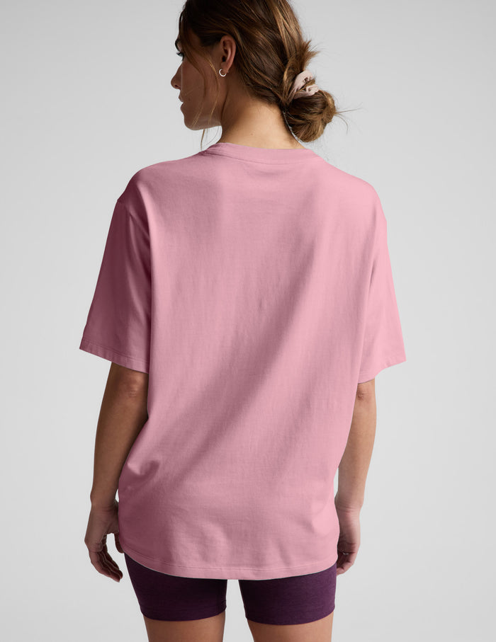 Woman wearing a pink t-shirt and purple shorts against a plain background.