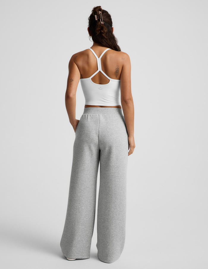 Woman wearing Gray SoftSpring™ Wide Leg Pant 29" from a rear view, paired with a white cropped tank top.