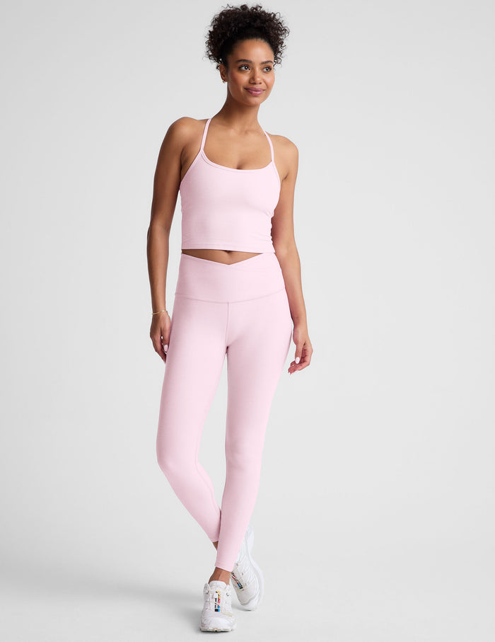 Woman wearing a pink athletic outfit on a light gray background
