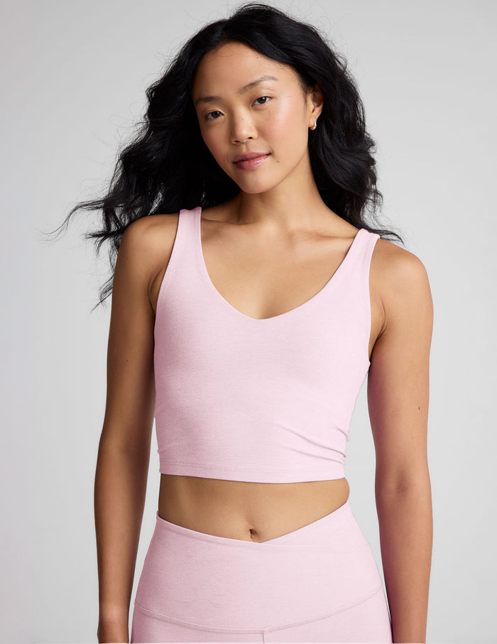 Woman wearing a pink athletic outfit with a plain background