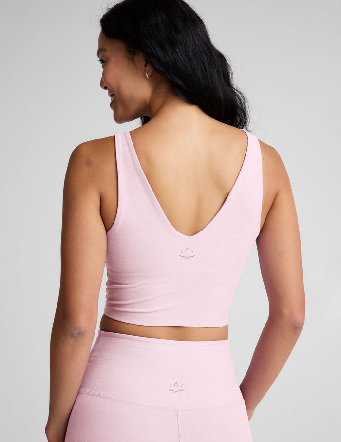 Woman wearing a pink athletic outfit with a plain background