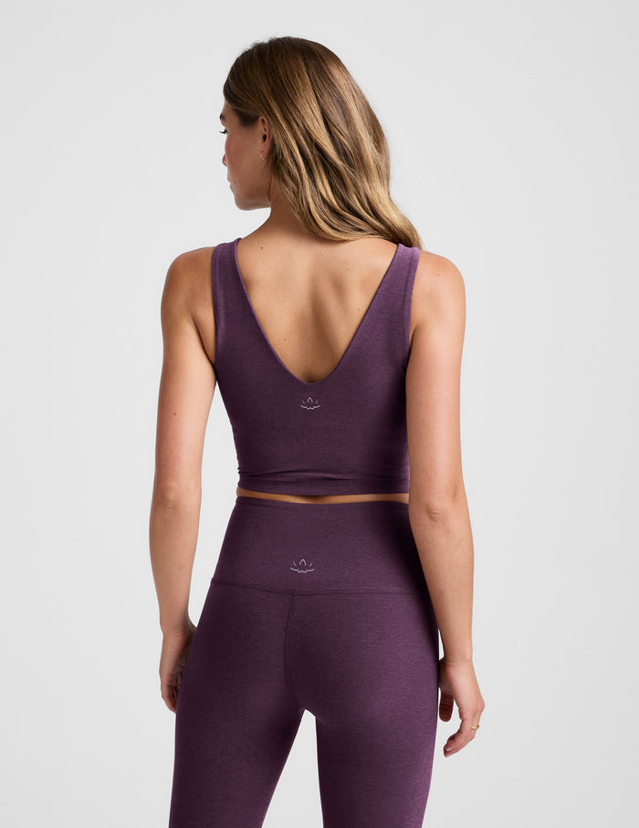 Woman wearing a purple athletic outfit on a light gray background.