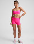 Woman wearing Fuchsia Spacedye Keep Pace 3" Mid-Rise Short paired with a matching sports bra and pink sneakers.