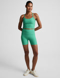 Model wearing bright green Spacedye Keep Pace 5" Biker Short with high waistband and matching tank, front-facing view.