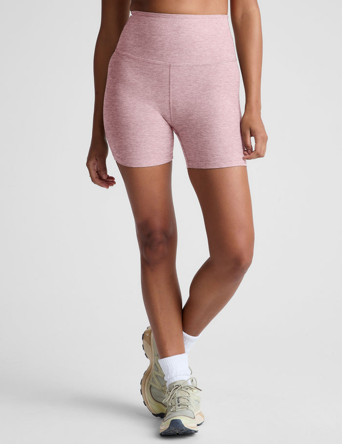 Pink marled Spacedye Keep Pace 5" Biker Short. High-waisted, mid-thigh yoga shorts shown on a model with beige sneakers.