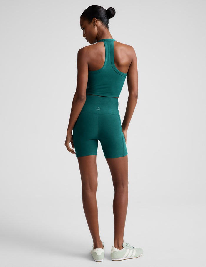 Woman wearing Teal Spacedye Keep Pace 5" Pocket Short™ with a matching racerback tank and sneakers, rear view.