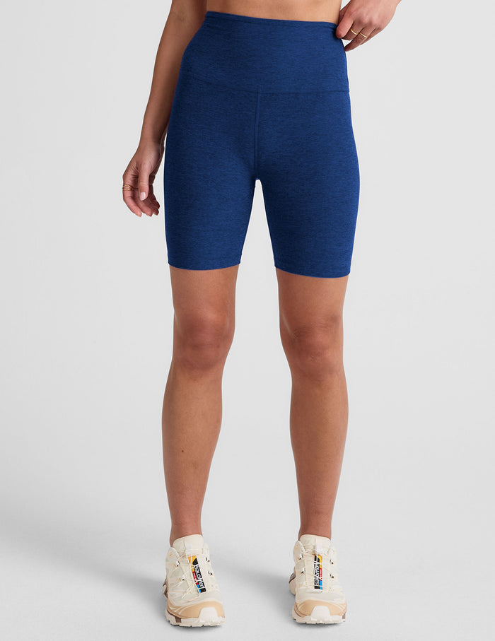 Front view of navy Spacedye Keep Pace 7" Short on a model. High-waisted, mid-thigh biker shorts with marled texture.