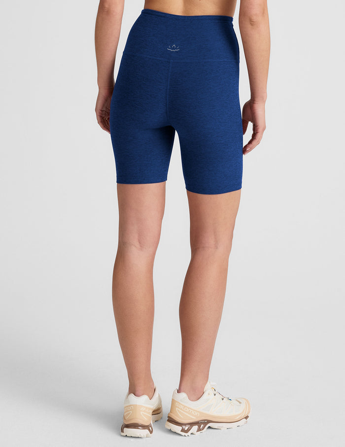 Rear view of navy Spacedye Keep Pace 7" Short. High-waisted marled biker shorts hitting mid-thigh on a standing model.