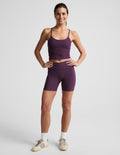 Woman wearing Purple Spacedye At Your Leisure™ 5" Biker Short paired with a matching tank top and cream sneakers.