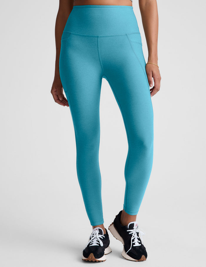 Person wearing blue leggings on a plain background.