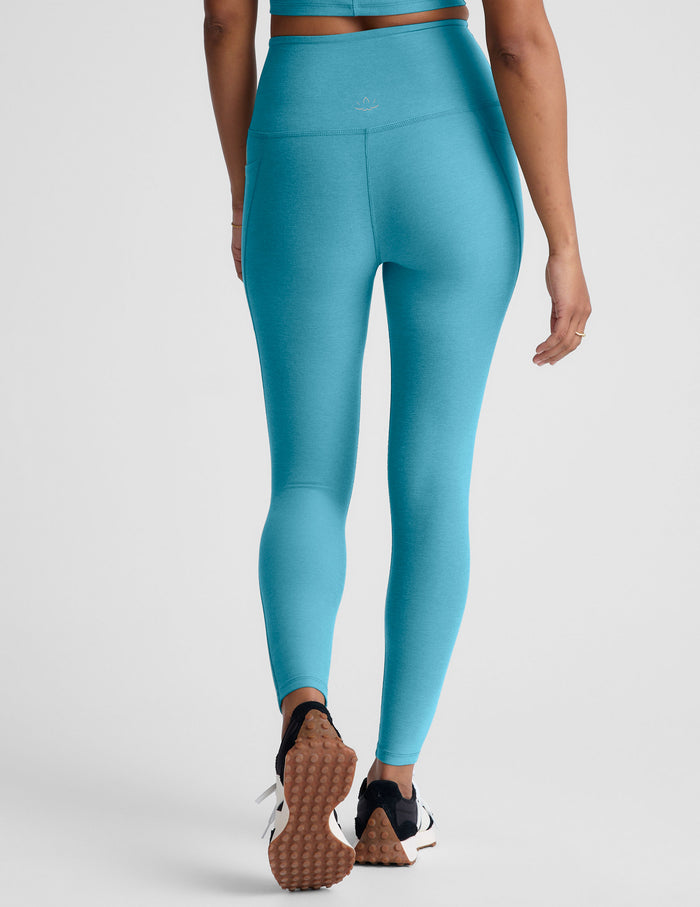 Person wearing blue leggings on a plain background.