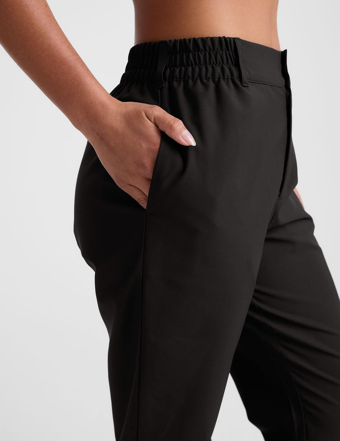 Side view of the black Status Tapered Pant featuring an elastic mid-rise waistband, belt loops, and a side seam pocket.