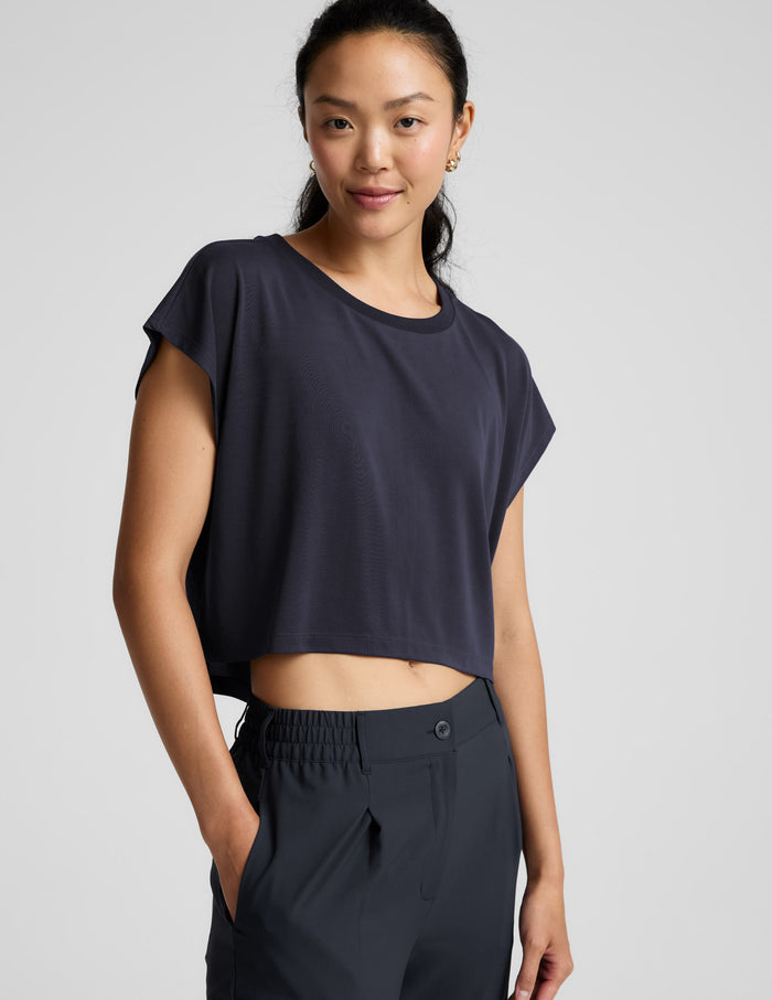 Woman wearing a blue shorts and trousers on a plain background.