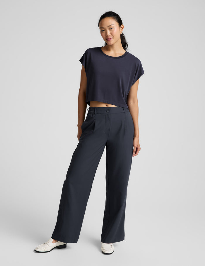 Woman wearing a blue shorts and trousers on a plain background.